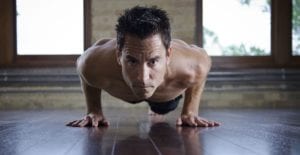 Sweaty-fit man doing HIIT yoga