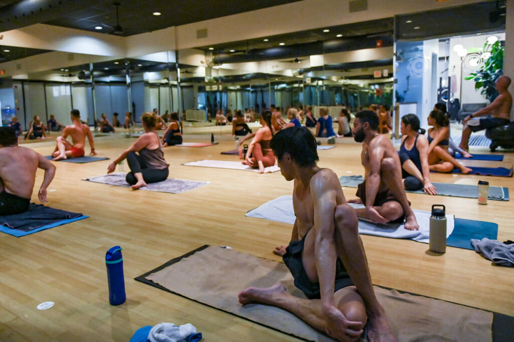 Bikram yoga class in twisting spine pose